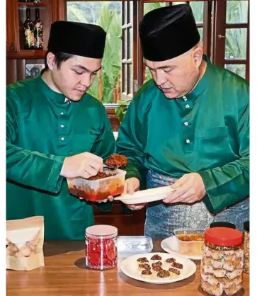  ??  ?? Make it yummy : Young national bowler Tun Ameerul Hakim Tun Hasnul Azam prepares the delicacies with his father.