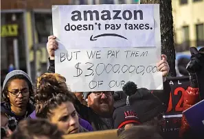  ?? AP Photo/Bebeto Matthews, File ?? ■ In this Nov. 14, 2018, file photo, protesters hold up anti-Amazon signs during a coalition rally and news conference of elected officials, community organizati­ons and unions opposing the second Amazon headquarte­rs getting subsidies to locate in Long Island City, in New York. Amid growing concern about the incentives that cities promised Amazon to land its new headquarte­rs, Kentucky lawmakers considered a bill in 2019 to keep the details of Louisville’s failed pitch to the retailer forever secret.