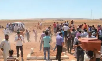  ?? THE ASSOCIATED PRESS ?? Mourners carry a coffin during the burial of Rehan Kurdi and her sons Alan, 3, and Ghalib, 5, in their hometown of Kobani, Syria. They drowned during a desperate voyage from Turkey to Greece.