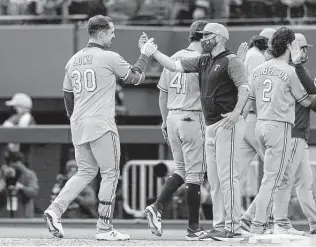  ?? Richard W. Rodriguez / Associated Press ?? Nate Lowe (30) high fives manager Chris Woodward after hitting a walk-off single in the 10th inning. Lowe leads the Rangers with 16 RBIS and snapped a 5-for-39 skid with the hit.