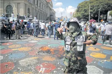 ?? REUTERS ?? A demonstrat­or wearing a military uniform takes part in a protest against the government in San Salvador on Sunday.