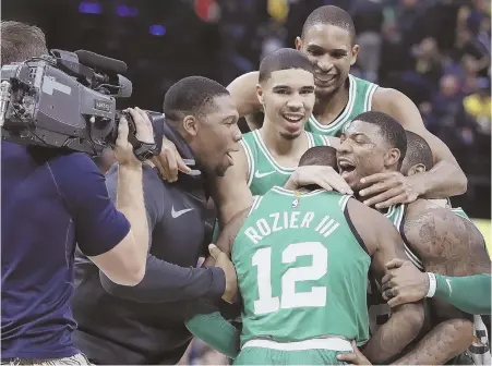  ?? AP PHOTO ?? PUMPED: The Celtics mob Terry Rozier after his last-second steal and dunk sent the Celtics to victory over the Pacers last night in Indianapol­is.