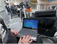  ?? AFP ?? A Syrian woman travelling to the US through Amman opens her laptop before checking in at Beirut internatio­nal airport. Emirates says its passengers who fly to the US via Dubai can use their laptops in the first part of their journeys. —