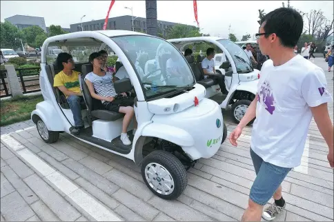  ?? SUN CAN / XINHUA ?? Students at Nanjing University in Jiangsu province try out cars powered by hydrogen fuel cells. The vehicles were developed by the Kunshan Innovation Institute at the