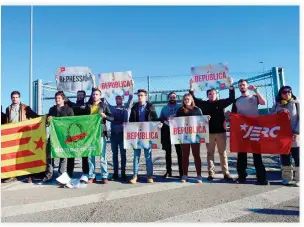  ??  ?? A group of people holds Catalan 'Estelada' flags and banners demanding a republic as they wait for the release of some Catalan former ministers outside the Estremera prison, some 80km east of Madrid, on Monday. (AFP)