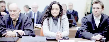  ??  ?? File photo shows Zschaepe (centre) sitting next to lawyers Hermann Borchert (left) and Mathias Grasel before the continuati­on of her trial at a courtroom in Munich. — Reuters photo