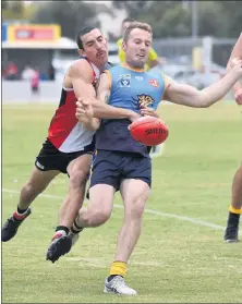  ??  ?? SETTING EXAMPLE: Nhill’s consistent Liam Albrecht attempts to get a kick away despite a fierce tackle from Horsham Saints’ Jacob O’beirne. While teams setting the pace will lock horns across the league, Nhill will start as underdog against Southern Mallee Giants. Picture: PAUL CARRACHER