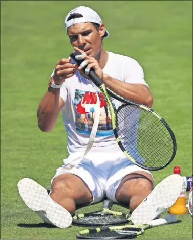  ??  ?? MANITAS. Rafa Nadal cambia el grip de la empuñadura de su raqueta antes de entrenarse.