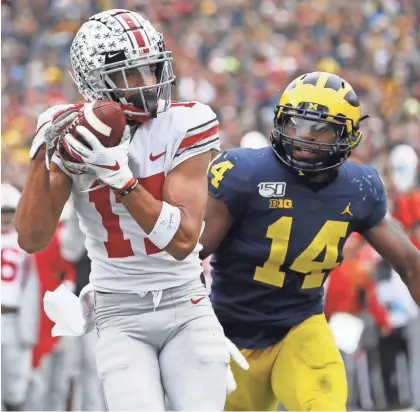  ?? ADAM CAIRNS/DISPATCH ?? Ohio State wide receiver Chris Olave, here catching a touchdown pass behind Michigan’s Josh Metellus in 2019, said one reason he returned to OSU this season was for one more game against the Wolverines.