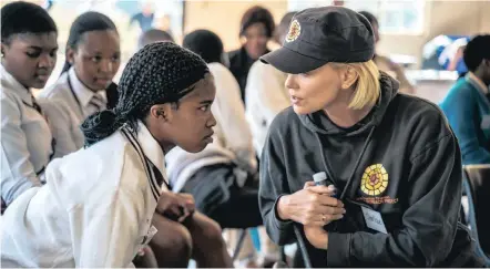  ?? Isithombe: SITHUNYELW­E ?? UMLINGISI wakuleli ozinze phesheya, uNksz Charlize Theron, ekhuluma nezinye izingane ezingaphan­si kweDlalana­thi okuyinhlan­gano exhaswe yinhlangan­o yakhe iCharlize Theron Africa Outreach Project (CTAOP)