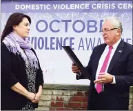  ?? Erik Trautmann / Hearst Connecticu­t Media ?? Norwalk Mayor Harry Rilling, right, reads a proclamati­on to representa­tives of the Domestic Violence Crisis Center, including Executive Director Suzanne Adam, left, and the Norwalk Police Department on Oct. 1, 2019, announcing October as Domestic Violence Awareness Month in front of Norwalk City Hall.