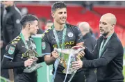  ??  ?? City manager Pep Guardiola, right, and his players celebrate with the League Cup trophy.