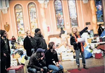  ?? Piotr Redlinski / New York Times ?? Anna Mains (right) helps organize Occupy volunteers helping with relief efforts at a donation distributi­on and collection center at the Church of St. Luke and St. Matthew in New York.