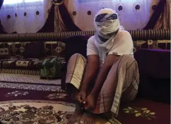  ?? MAAD EL ZIKRY PHOTOS /THE ASSOCIATED PRESS ?? A former detainee shows how he was kept in handcuffs and leg shackles while held in a secret prison at Riyan airport in the Yemeni city of Mukalla. He covered his face for fear of being detained again.