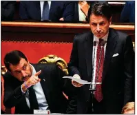  ?? AP/ANSA/ETTORE FERRARI ?? Matteo Salvini (left), Italy’s interior minister, listens Tuesday as Premier Giuseppe Conte resigns during an address in the Senate in Rome. “I’d do it all again,” Salvini said of his call for early elections.