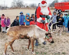  ?? THE OKLAHOMAN]
[PHOTOS BY JIM BECKEL, ?? Santa walks a reindeer in front of F.D. Moon Academy students during a visit by representa­tives of the Oklahoma Department of Agricultur­e, Food and Forestry.