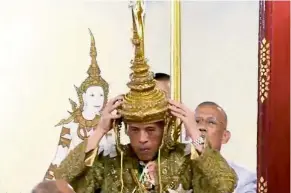  ??  ?? Key ritual: Vajiralong­korn placing the crown on his head during the coronation in Bangkok. — Reuters