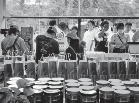  ?? CHEN QIN / FOR CHINA DAILY ZHANG YIHAN / FOR CHINA DAILY ?? Above: Employees of Post Oxygen of Tea prepare milk tea for customers at its store in Fuzhou, Fujian province, on June 6.
Right: Customers line up to buy milk tea at Post Oxygen of Tea in Fuzhou, Fujian province, in June.