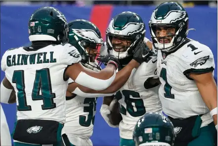 ?? JOHN MINCHILLO / THE ASSOCIATED PRESS ?? Eagles running back Miles Sanders, second from right, celebrates with quarterbac­k Jalen Hurts, far right, and other teammates after scoring a fourth-quarter touchdown against the New York Giants in January. Now the team vies to win the Super Bowl this Sunday.