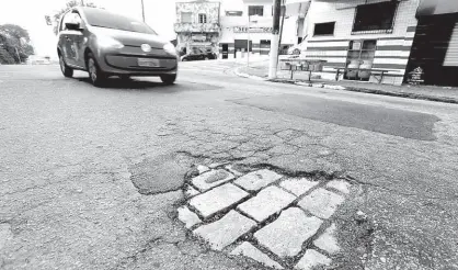  ?? Robson Ventura/Folhapress ?? Carro passa perto de buraco na avenida Ibitirama, na Vila Prudente (zona leste de SP), que teve serviço de tapa-buraco suspenso por 120 dias desde 25 de maio; prefeitura regional alegou falta de grana