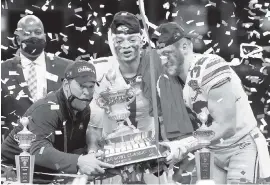 ?? CHRIS GRAYTHEN Getty Images ?? Ohio State coach Ryan Day, Justin Fields (1) and Tuf Borland (32) lift the trophy after defeating Clemson 49-28 in a CFP semifinal on Friday night in New Orleans.