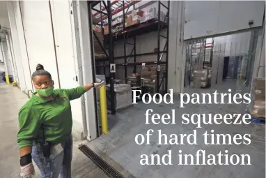  ?? ?? Teresa Fleming points towards the freezer at the Mid-south Food Bank on Sept. 23 where, because of discontinu­ed provisions, they have seen a drop of more than a third of their overall food supply.