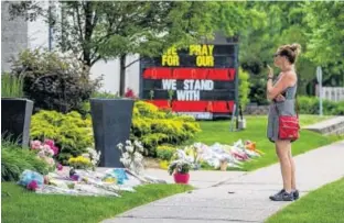  ?? REUTERS ?? A woman stops in front of the London Muslim Mosque, about 500 metres from where police arrested a suspect in the killing of four members of a Muslim family in London, Ont.