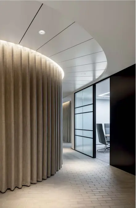  ??  ?? Above — The curtains bring a softness to the materials palette, which helps to create enveloping and reassuring meeting spaces for clients.