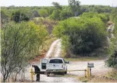  ??  ?? A Border Patrol agent locks a gate on property belonging to the National Butterfly Center as he patrols the border.