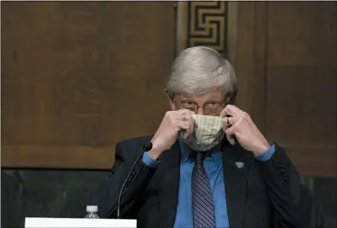  ?? ANNA MONEYMAKER/THE NEW YORK TIMES VIA AP, POOL ?? National Institutes of Health Director Dr. Francis Collins puts on his face mask after a Senate Health Education Labor and Pensions Committee hearing on new coronaviru­s tests on Capitol Hill in Washington.