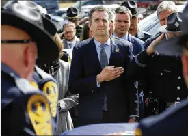  ?? STEVE HELBER / AP ?? Gov. Ralph Northam watches as the casket of fallen Virginia State Trooper Lucas B. Dowell is carried to a waiting tactical vehicle Saturday during the funeral at the Chilhowie Christian Church in Chilhowie. Dowell was killed in the line of duty earlier in the week. It was Northam’s first public appearance in a week.