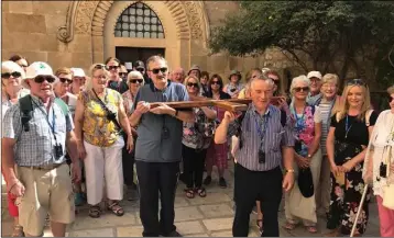  ??  ?? The Enniscorth­y pilgrims carrying a cross in Jerusalem at the Church of the Flagellati­on.