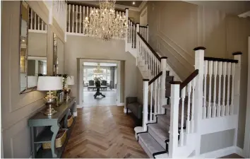  ??  ?? Horsey themed: Clockwise from right: the herringbon­e hall floor and the hipped staircase with Ventura signature chandelier overhead; the porched frontage with 400 sq ft garage; an open plan living and dining space; another view of the hall with vestibule table and mirrors also showing the overhead gallery landing