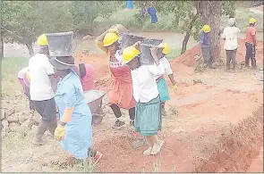  ?? ?? Women ferrying sand to the constructi­on site.