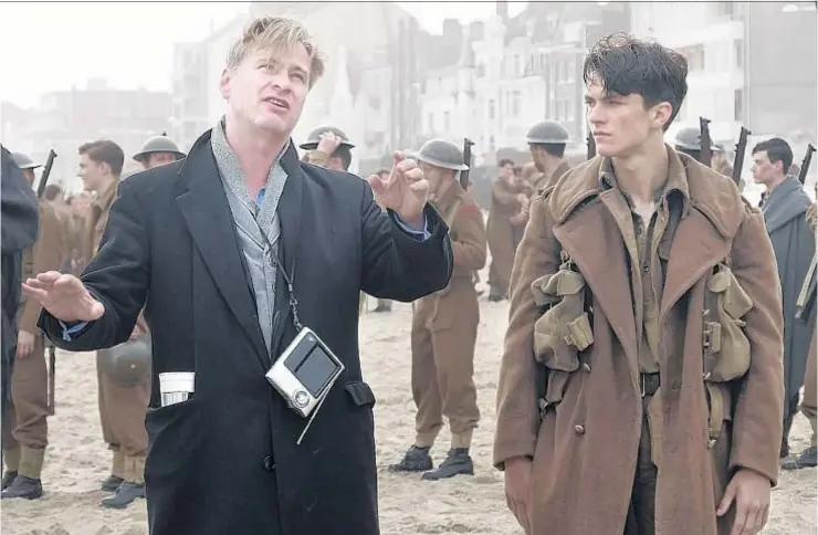  ?? Melinda Sue Gordon Warner Bros. Pictures ?? CHRISTOPHE­R NOLAN, left, gives Fionn Whitehead guidance during “Dunkirk” filming. The director says he went outside his comfort zone in making the film.