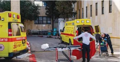  ?? (Chaim Goldberg/Flash90) ?? EMERGENCY MEDICAL personnel act near ambulances that brought wounded citizens from a terror attack in the Jordan Valley, at Hadassah-University Medical Center on Jerusalem’s Mount Scopus yesterday.