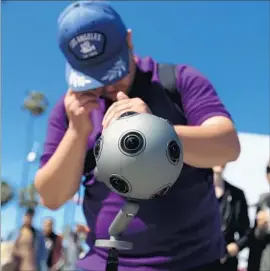  ?? Rick Loomis Los Angeles Times ?? ROBERT COSNAHAN, a crew member with Chinese digital media company FansTang, checks on a Nokia OZO virtual reality camera at Venice Beach.