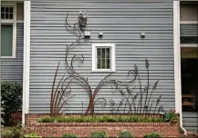  ??  ?? Homeowners Kate and Carl Seville worked with Andrew T Crawford Ironworks, who created a beautiful climbing sculpture on the westfacing side of their home.