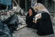  ?? ALICE MARTINS FOR THE WASHINGTON POST ?? Aya Abosh weeps next to body bags containing the remains of her sister and two nephews in the Old City of Mosul.