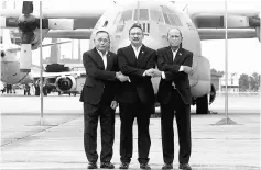  ??  ?? Hishammudd­in in a show of unity with Ryamizad Ryacudu (left) and Delfin N. Lorenzana (right) after launching the Trilateral Air Patrol at Royal Malaysian Air Force Base in Subang. — Bernama photo