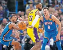  ?? OKLAHOMAN] ?? Lakers forward LeBron James (23) passes the ball behind his back away from the Thunder's Danilo Gallinari (8) and Terrance Ferguson in a Nov. 22 game in Oklahoma City. [NATE BILLINGS/ THE