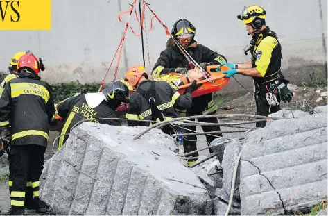  ?? LUCA ZENNARO / ANSA VIA AP ?? Firefighte­rs rescue a person from the rubble of the collapsed Morandi highway bridge in Genoa, Italy, on Tuesday.