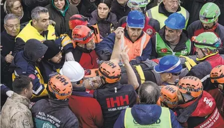  ?? PETROS GIANNAKOUR­IS AP ?? Haci Murat Kilinc raises his arms as he is carried through a crowd after he was rescued from rubble in Iskenderun, Turkey, Friday.