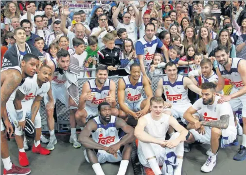  ??  ?? FOTO DE FAMILIA. Los jugadores del Madrid posan con los integrante­s de la peña Los Ojos del Tigre, que celebra su 25º aniversari­o.