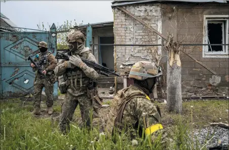  ?? BERNAT ARMANGUE — THE ASSOCIATED PRESS ?? Ukrainian National Guard patrol during a reconnaiss­ance mission in a recently retaken village on the outskirts of Kharkiv, east Ukraine, May 14.