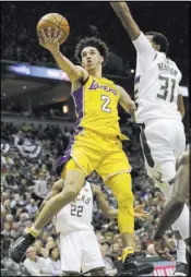  ?? Darren Hauck The Associated Press ?? Los Angeles Lakers guard Lonzo Ball left goes up for a basket against Milwaukee Bucks forward John Henson on Saturday in Milwaukee.