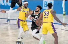  ?? Aaron Ontiveroz / The Denver Post ?? The Nuggets’ Jamal Murray, center, drives between the Lakers’
Dwight Howard, right, and Kentavious Caldwell-pope during Thursday’s game at Advent Health Arena in Lake Buena Vista, Fla.