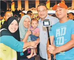  ??  ?? Members of the public grab the chance for a we-fie with Defence Minister Datuk Seri Hishammudd­in Hussein (second right).