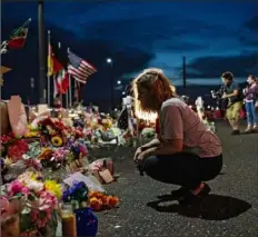  ?? Tamir Kalifa/The New York Times ?? Jackie Hernandez kneels at a makeshift memorial Aug. 27 for victims of the shooting that killed 22 people at a Walmart in El Paso, Texas.