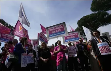  ?? Alessandra Tarantino/Associated Press ?? People hold banners reading “we are families, not crimes” during a pro-surrogacy flash-mob in Rome on Friday. The rally was organized to counter proposals by Italy’s hard-right-led government to make it a crime for Italians to try to use surrogates abroad, even in countries where the practice is legal.